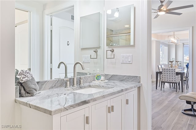 bathroom with vanity, ceiling fan, walk in shower, and hardwood / wood-style floors