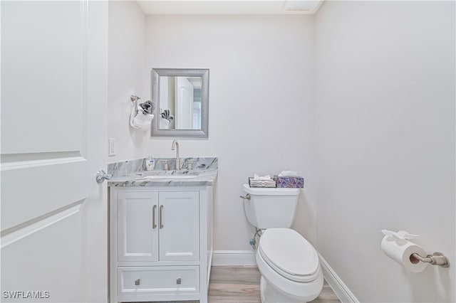 bathroom featuring vanity, toilet, and hardwood / wood-style flooring