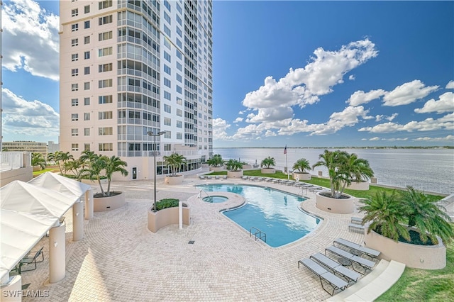 view of swimming pool with a patio area and a water view