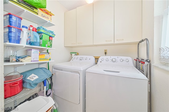 laundry room featuring cabinets, a textured ceiling, and separate washer and dryer