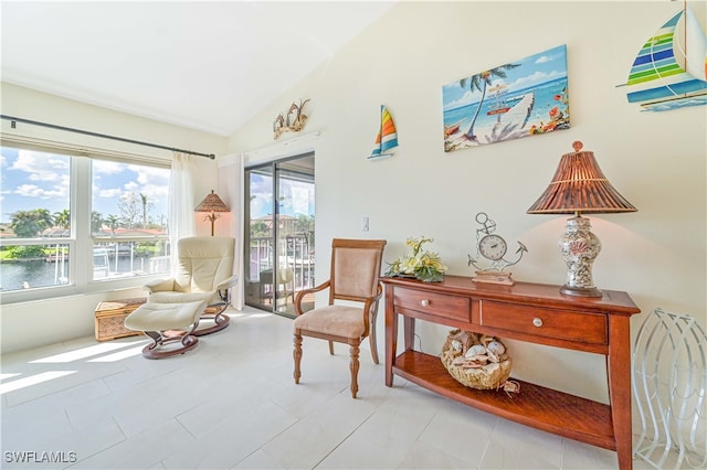 living area featuring a water view, light tile patterned floors, and lofted ceiling