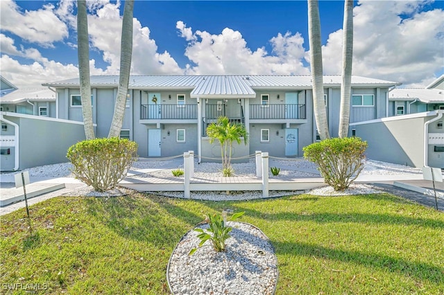 multi unit property featuring a front yard and a balcony