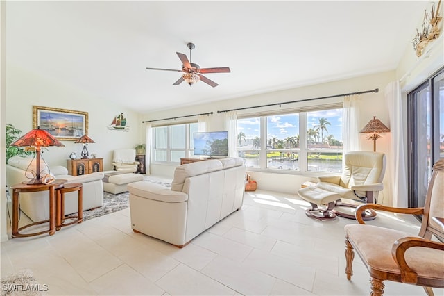 tiled living room with ceiling fan and lofted ceiling