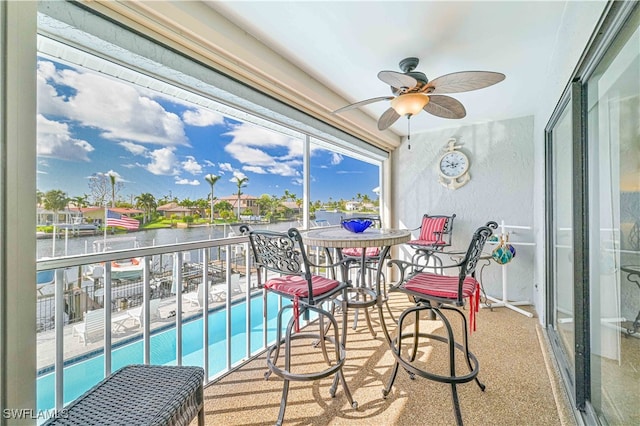 balcony with a water view and ceiling fan