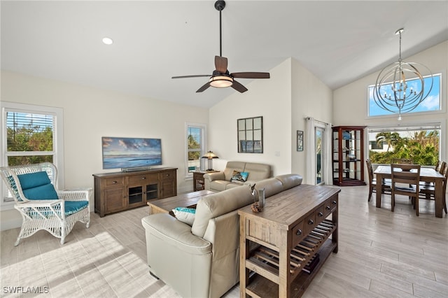 living room with ceiling fan with notable chandelier, light wood-type flooring, and lofted ceiling