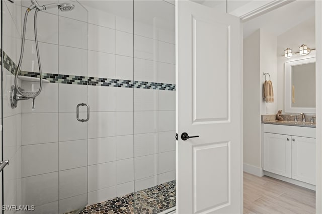 bathroom featuring vanity, an enclosed shower, and wood-type flooring