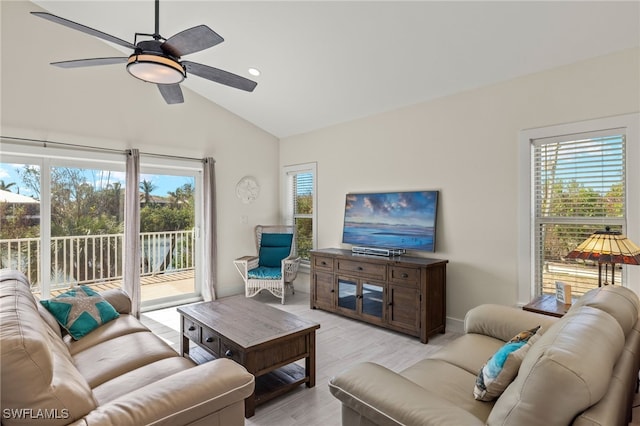 living room featuring light hardwood / wood-style floors, vaulted ceiling, and ceiling fan