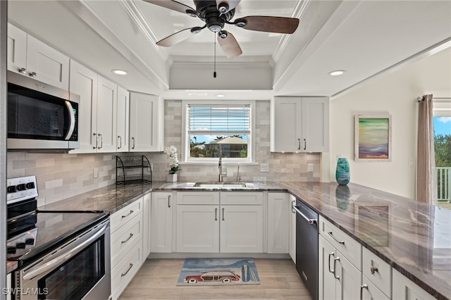 kitchen featuring a raised ceiling, sink, white cabinets, and appliances with stainless steel finishes