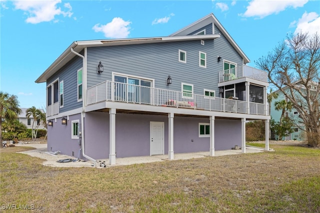 back of property with a lawn, a sunroom, and a deck