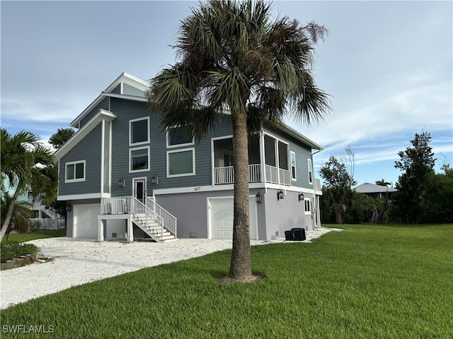 view of front of house featuring central air condition unit, a front lawn, and a garage