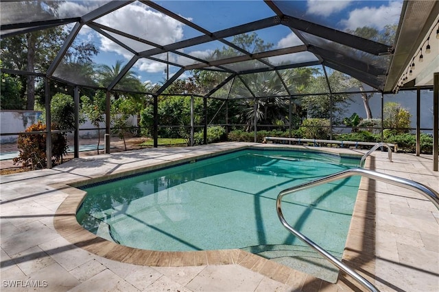 view of pool featuring glass enclosure and a patio area