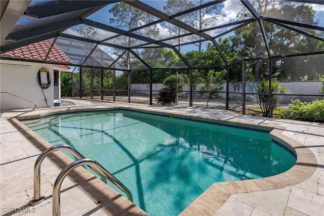 view of swimming pool featuring glass enclosure and a patio area