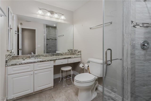 bathroom featuring vanity, toilet, and a shower with door