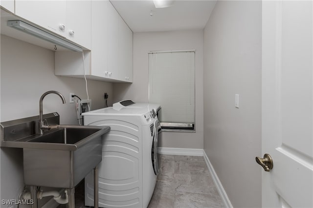 laundry room featuring cabinets, separate washer and dryer, and sink