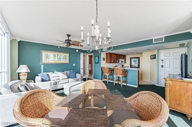 dining room with light carpet, ornamental molding, ceiling fan with notable chandelier, and visible vents