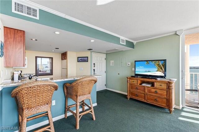 kitchen featuring light countertops, freestanding refrigerator, visible vents, and a healthy amount of sunlight