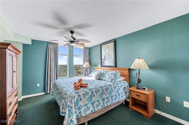 carpeted bedroom with ceiling fan and baseboards