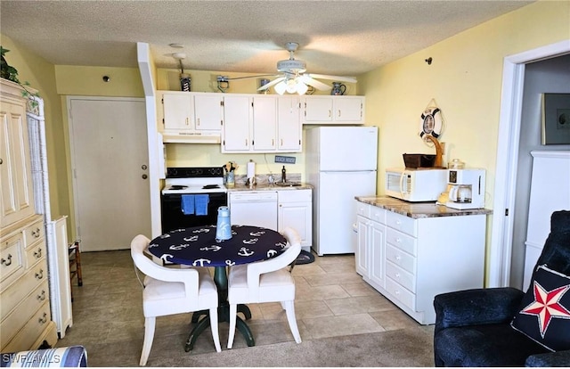 kitchen featuring ceiling fan, a textured ceiling, white cabinets, and white appliances