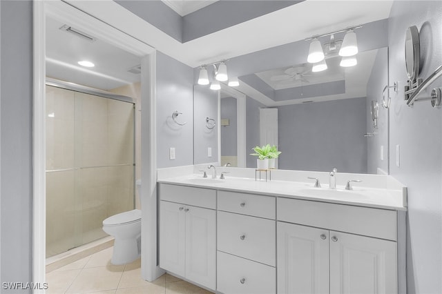 bathroom with a tray ceiling, an enclosed shower, toilet, tile patterned floors, and vanity