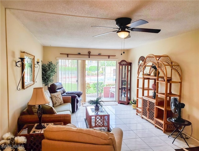 living room with light tile patterned floors, a ceiling fan, and a textured ceiling