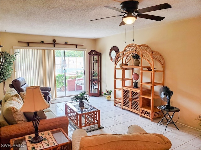 living room featuring ceiling fan, a textured ceiling, and light tile patterned floors