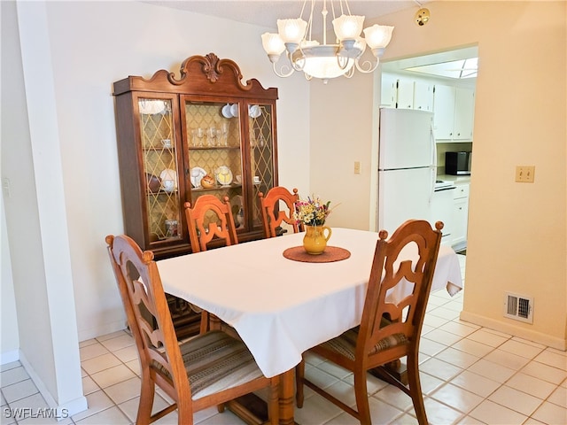 dining room featuring an inviting chandelier and light tile patterned floors