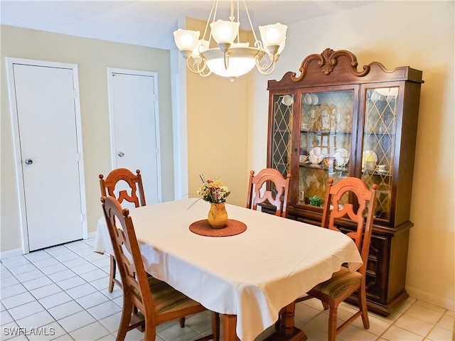 tiled dining room featuring a notable chandelier