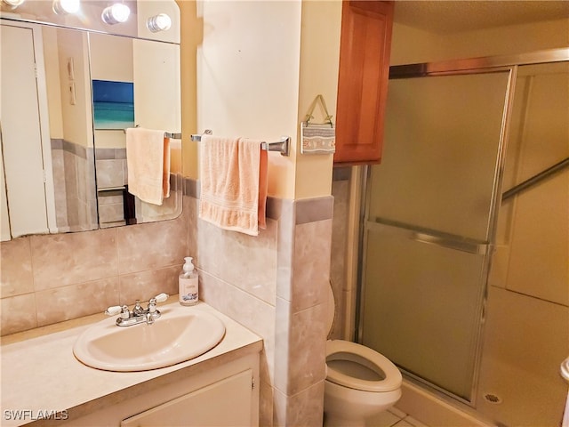 bathroom with vanity, toilet, decorative backsplash, and an enclosed shower