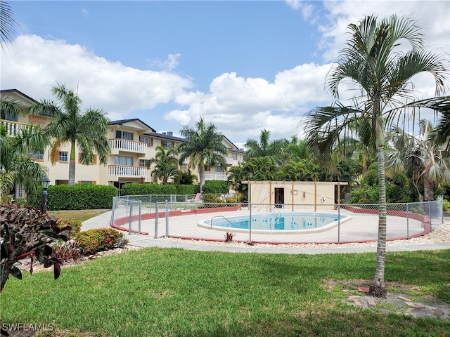 view of pool with a lawn