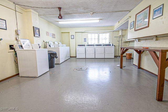 clothes washing area with washing machine and dryer and a textured ceiling