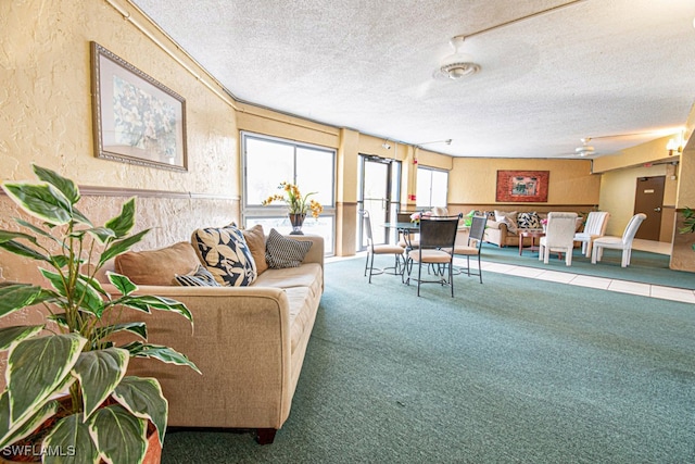 carpeted living room with ceiling fan and a textured ceiling