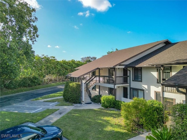 800 Misty Pines Cir Unit H-201, Naples, FL 34105 - view of property featuring stairs and uncovered parking