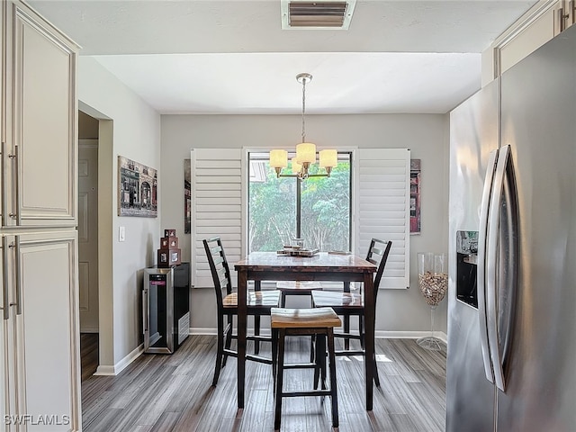 dining area with light wood-type flooring and a chandelier