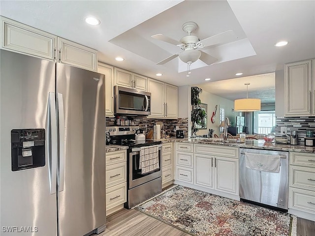 800 Misty Pines Cir Unit H-201, Naples, FL 34105 - kitchen with stainless steel appliances, a raised ceiling, a sink, a ceiling fan, and tasteful backsplash