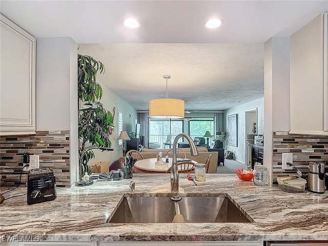 800 Misty Pines Cir Unit H-201, Naples, FL 34105 - kitchen with a sink, light stone countertops, open floor plan, tasteful backsplash, and pendant lighting
