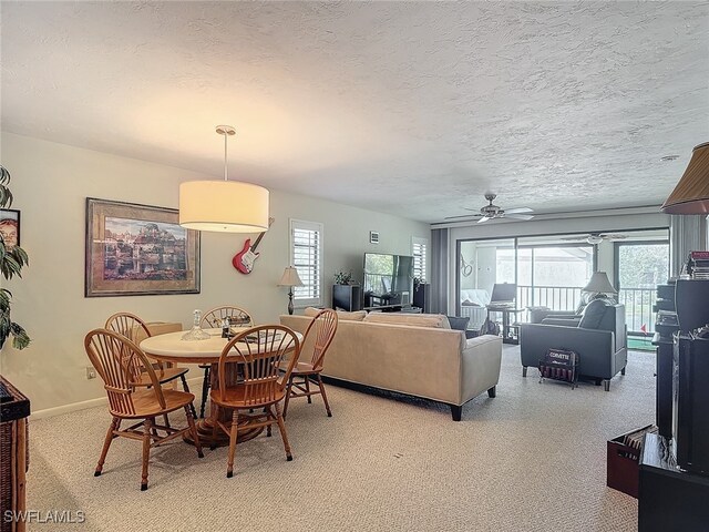 carpeted dining room with a textured ceiling and ceiling fan