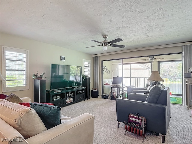 living room featuring a wealth of natural light, ceiling fan, a textured ceiling, and carpet flooring