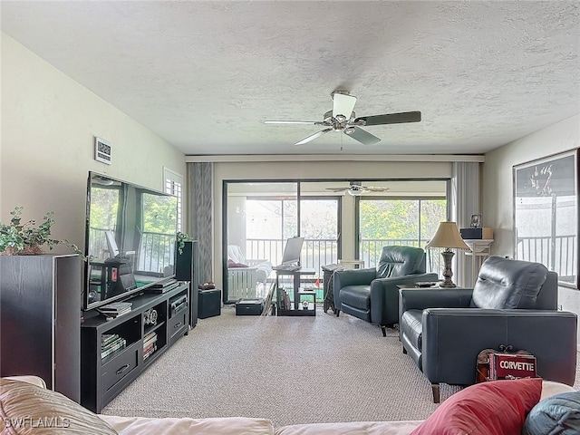 living room featuring carpet, a textured ceiling, and ceiling fan