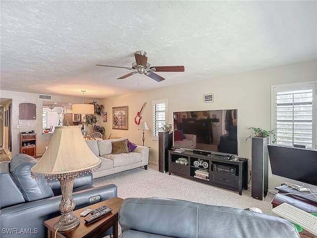 living room featuring a wealth of natural light, ceiling fan, and light colored carpet