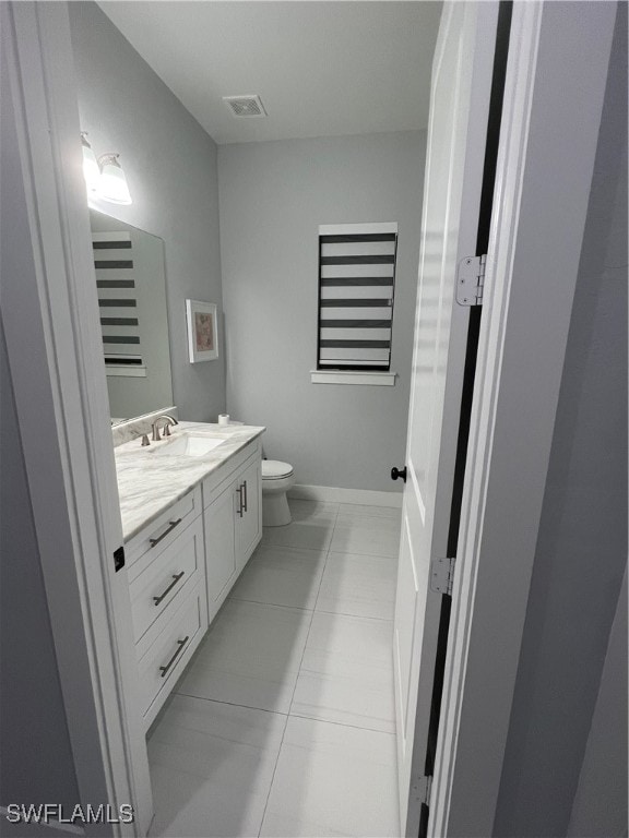 bathroom featuring toilet, vanity, and tile patterned floors