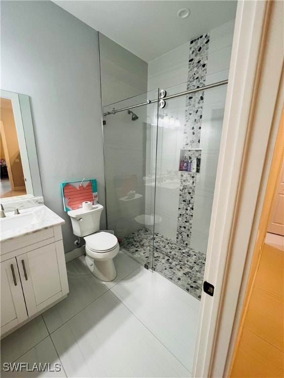 bathroom with vanity, tile patterned flooring, toilet, and an enclosed shower