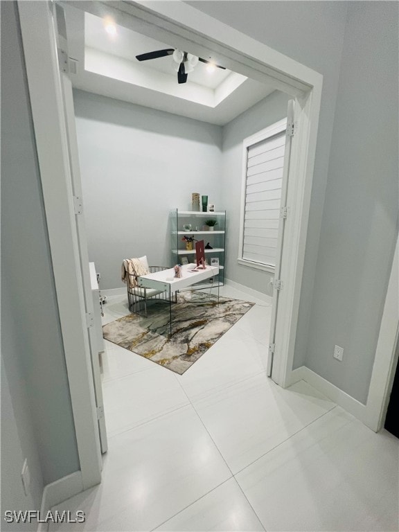 office area featuring ceiling fan, a raised ceiling, and tile patterned flooring