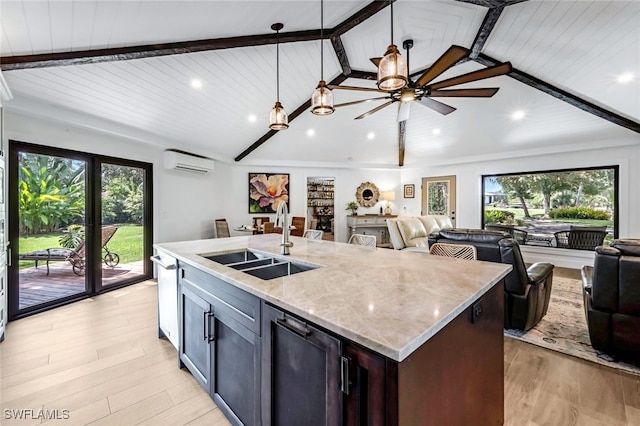 kitchen featuring a wall mounted AC, a wealth of natural light, sink, and pendant lighting