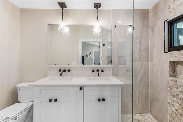 bathroom featuring vanity, toilet, and tiled shower