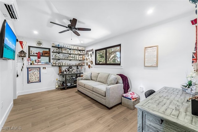 living room featuring bar area, light hardwood / wood-style floors, a wall unit AC, and ceiling fan