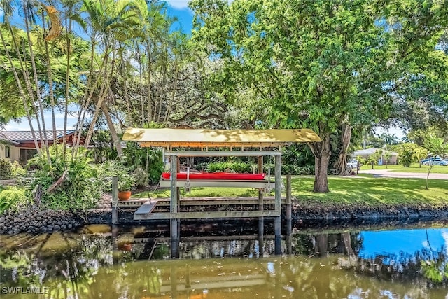 view of dock featuring a lawn and a water view