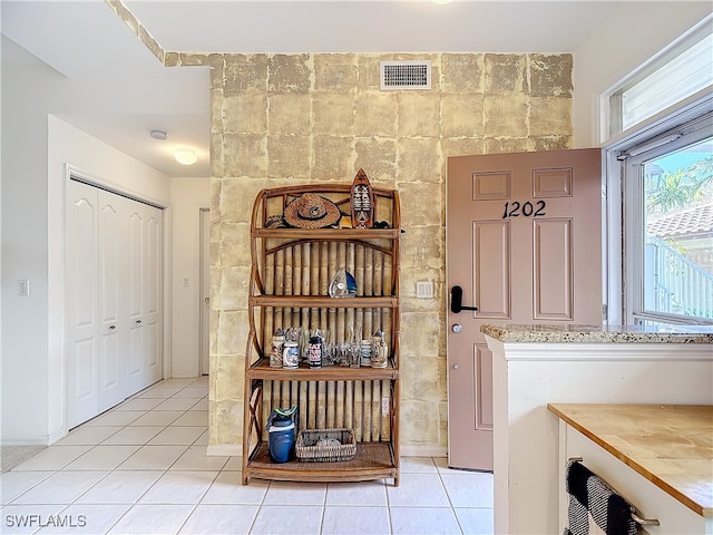 clothes washing area featuring light tile patterned floors