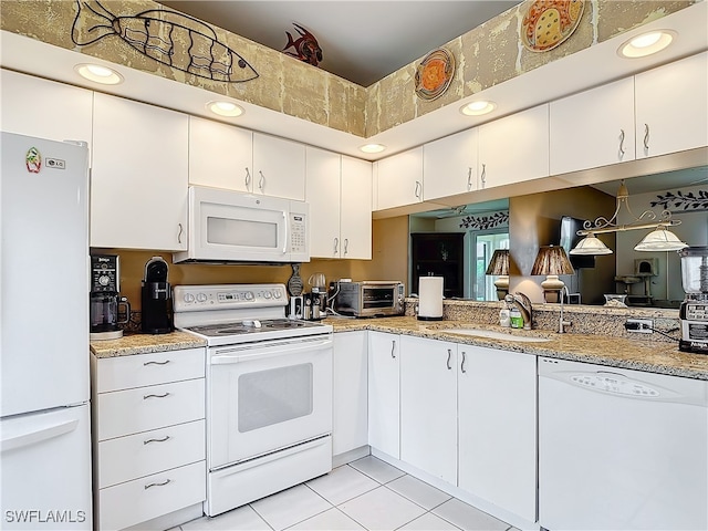 kitchen with white appliances, white cabinetry, and sink