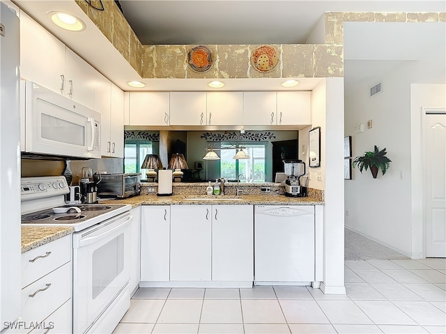 kitchen featuring sink, light tile patterned floors, white cabinets, light stone counters, and white appliances