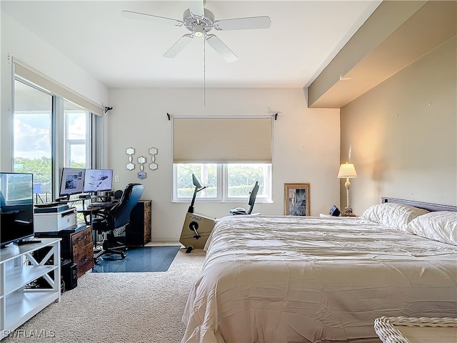 carpeted bedroom featuring multiple windows and ceiling fan